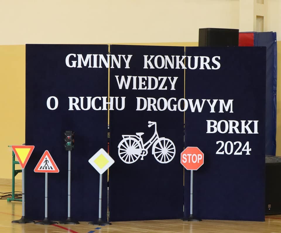 dekoracja na niebieskim tle z napisem gminny konkurs o ruchu drogowym i znaki drogowe
