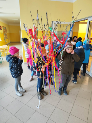 grupa przedszkolaków ubrana na kolorowo trzymająca w rękach kolorowe wstążki