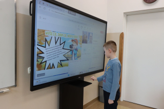 uczeń stojący przy monitorze interaktywnym i wykonująca ćwiczenie w ramach webinaru
