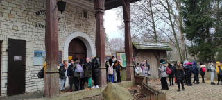 grupa uczniów stojąca przed wejściem do muzeum wsi lubelskiej