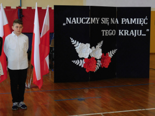 uczeń stojący na tle flag