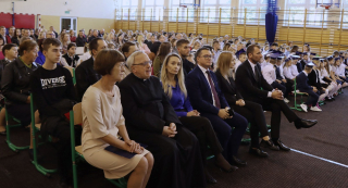 publiczność na szkolnych obchodach dnia papieskiego (ksiądz, dyrektor, wójt  oraz pozostali uczestnicy)