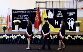 poczet sztandarowy szkoły występujący do ślubowania, w tle dekoracja dnia papieskiego